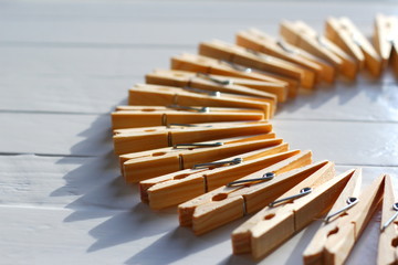 Wooden clothes pegs placed in a circle on a white wooden table
