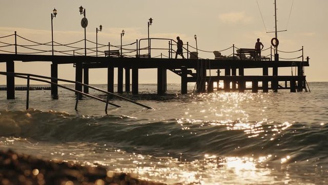 People relax and sunbathe on the pier in the early morning.