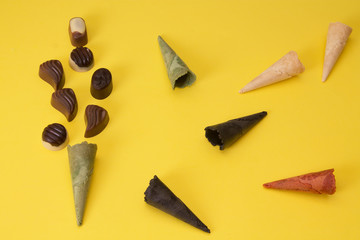 ice cream cones and chocolates on yellow background