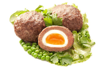 Egg wrapped in minced meat with vegetable garnish
