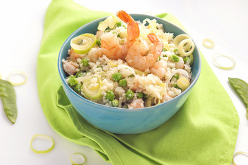 blue bowl of rice and shrimps and vegetables on a green napkin