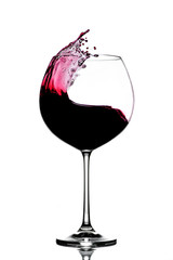 splash of red wine in a glass on a white background