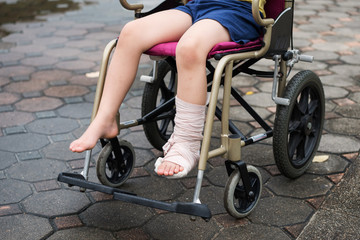 Obraz na płótnie Canvas Leg broken boy sit on wheelchair