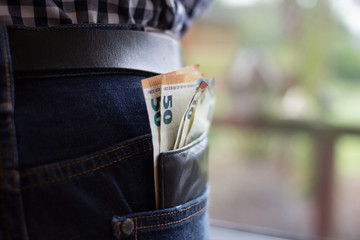 Geldscheine stecken in einer Geldbörse die aus einer Hosentasche ragt