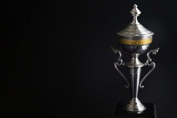 Close up of Silver trophy over black background. Winning awards with copy space for text and design.
