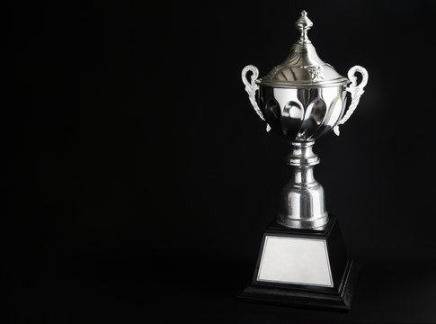 Silver trophy over black background. Winning awards with copy space for text and design.
