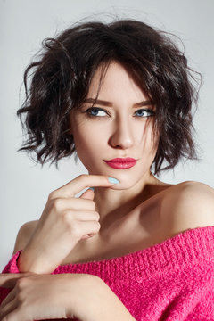 Sexy woman with short hair cut in pink red sweater on white background. Perfect girl with wet tousled dark hair and bright makeup, short hair, beauty and hair care. Naked shoulder women