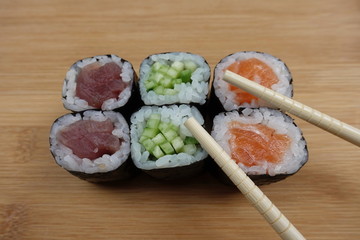 Sushi maki rolls, traditional japanese dish with two wooden sticks 
