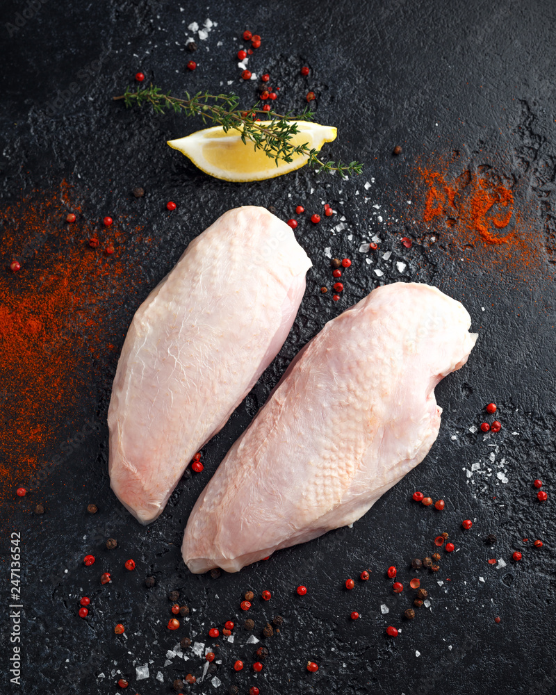 Wall mural Raw duck breast with seasonings on rustic black background