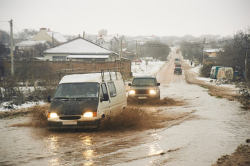 car goes by broken dirty road. bad roads condition problem concept.