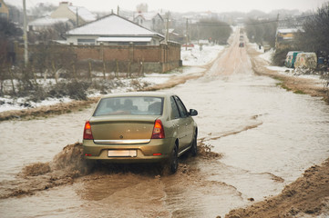 car goes by broken dirty road. bad roads condition problem concept.