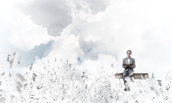 Young businessman or student studying the science and symbols fly around