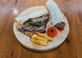 Turkish Doner Kebab, Shawarma or Gyros. Traditional Turkish Doner Kebab meat wrap, shawarma or gyros in restaurant