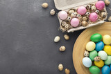Colored Easter and quail eggs set on black table