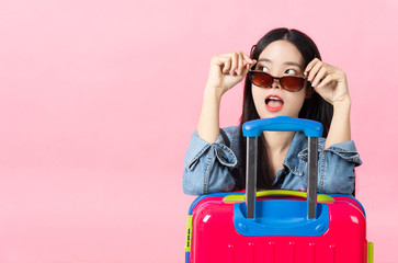 Traveler tourist woman in summer casual clothes.Asian Smiling woman wearing sun glasses.Passenger traveling abroad to travel on pink background.
