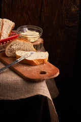 Bakery - gold rustic crusty loaves of bread and buns on black chalkboard background. Still life captured from above