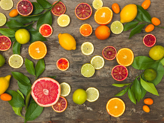 many different juicy and healthy citrus fruits lie together on an old, vintage wood background