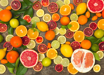 many different juicy and healthy citrus fruits lie together on an old, vintage wood background