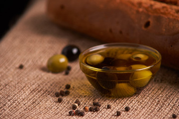 fresh bread baguette with olive oil, olives. cheese and rosemary on wooden background. Teasty breakfast
