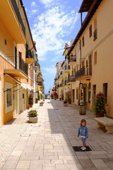 A little girl standing in the picturesque Italian village. San Felice Circeo, Lazio, Italy
