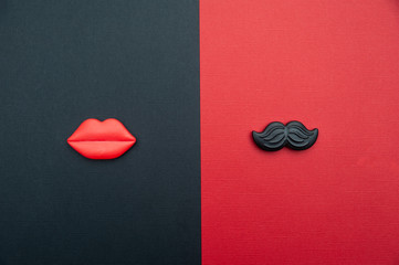 Сoncept of male and female. Flat Lay, red and black, red lips and black mustache, as a symbol of...