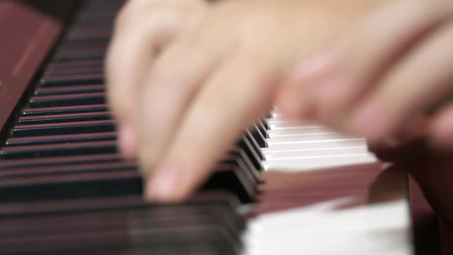 Close up view of child hands playing on the electric piano, 4k