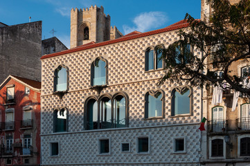The Casa dos Bicos at the Campo das Cebolas, with the bell tower of the Lisbon Cathedral on the background, in the city of Lisbon, Portugal