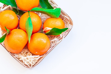 Tangerines with green leaves in a basket 