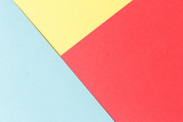 Abstract geometric festive background: red, yellow, blue. Paper background top view, minimalistic concept.