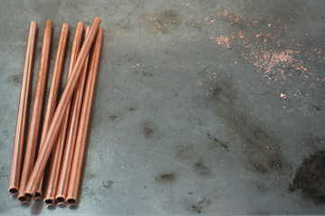 Stack of brass pipes on a fitter workbench background with copy space.