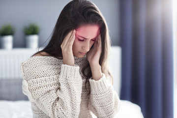 Adult woman suffering from headache at home