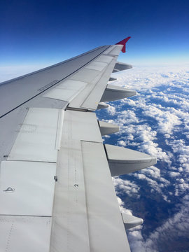 Blick auf den Fl&uuml;gel eines Flugzeuges &uuml;ber den Wolken