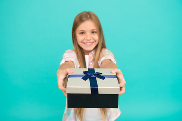 This is for you. Little shopaholic giving present wrapped in box. Small child with gift box tied with ribbon bow. Cute shopper enjoy doing a little shopping. Small girl after shopping for gift