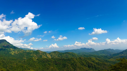 Panoramic view of summer green mountains, blue sky and white clouds. Beautiful nature landscape.