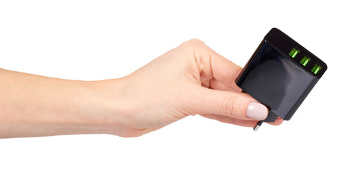 Obraz na płótnie Canvas Hand with black USB wall chrger plug, three ports.