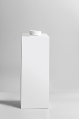 White packaging pack standing on light gray background, front view. Empty template box milk or...