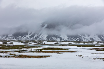 Isländische Winterlandschaft mit Bergen, See und Moos