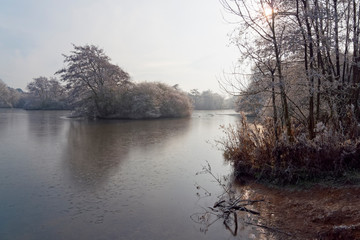 Low winter sun reflects off the surface of a frozen lake