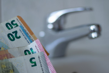 Euro Geldscheine vor Wasserhahn. Konzept für Wasserverbrauch