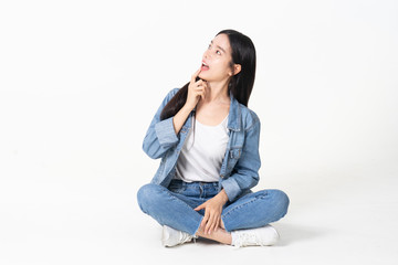 Thinking asian woman sitting on floor isolated on white background.Asian female model smiling...