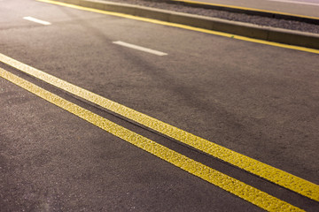 Wide bright double yellow marking sign line along modern wide smooth empty asphalt highway street stretching to horizon. Speed, safety, comfortable journey and professional road building concept.