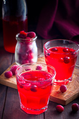 Refreshing vitamin cranberry drink in glass cups on a wooden table, selective focus