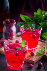 Refreshing vitamin cranberry drink in glass cups on a wooden table, selective focus