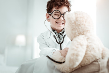 Delighted brunette child dreaming to become doctor