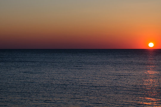 Fototapeta Beautiful sunset over the sea. The setting sun beyond the horizon. Seascape