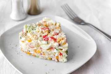 crab salad plate with egg, cucumber, corn, spices, fork