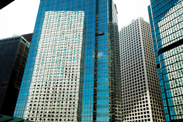 Abstract Windows Glass Fragment of Building architecture, pattern of window frame for office tower reflect other building skyscraper in day time blue sky background