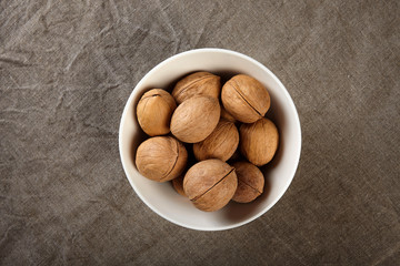 Bowl of walnuts on linen cloth.