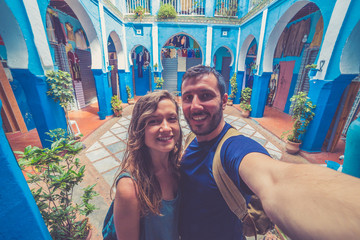 happy couple taking selfie in the streets of medina of Morocco Marrakesh