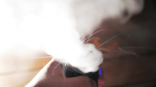Steam when using vape device, RDA atomizer without top cap, low Ohm clapton coils and vapour from e-liquid, close up
